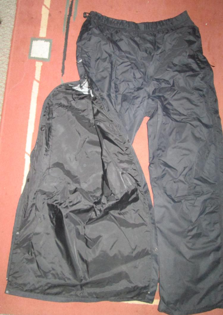 A pair of berghaus deluge waterproof pants with the full leg zip shown open
