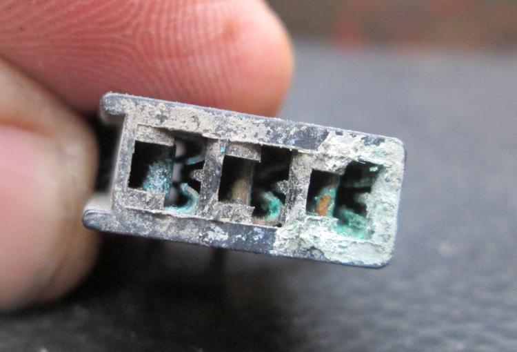 The connector block covered in green crud and grime