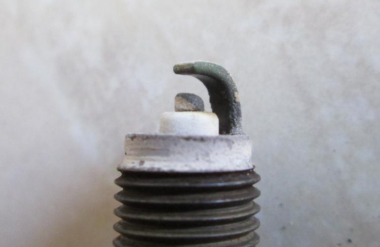 the tip of a spark plug from the CBF, in fair condition but the base is a bit white