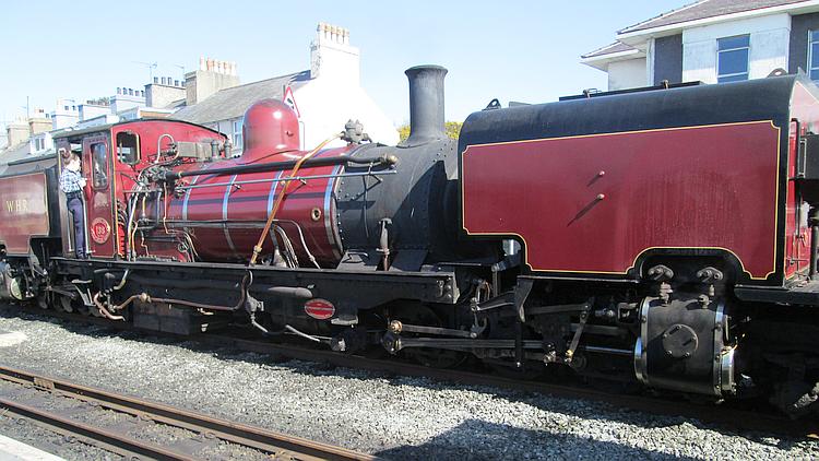 A narrow guage steam train at the station in porthmadog, wales