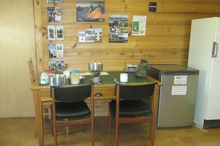 The stove on a table with 2 chairs at the campsite's common room