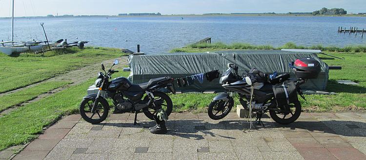 2 125cc motorcycles on a camnpsite in the Netherlands next to the dykes