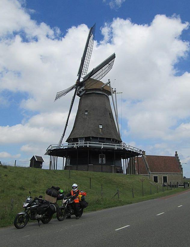 Sharon on her bike beneath a large Dutch windmill
