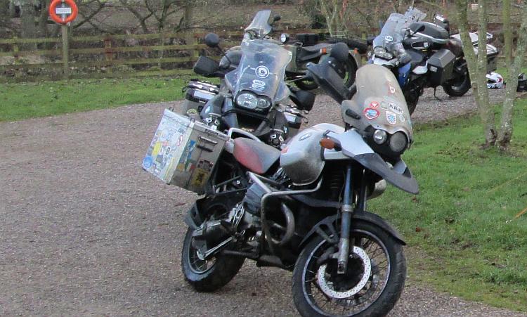 Several large BMW GS adventure bikes at a campsite