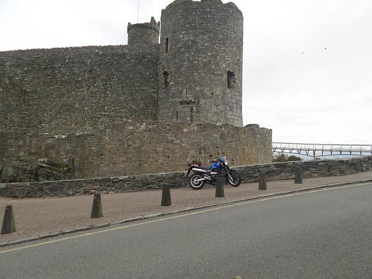 The bright blue 650 outside the massive walls of Harlech castle