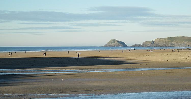 Perranporth beach is broad flat sandy beach. There is a number of people about but not too busy