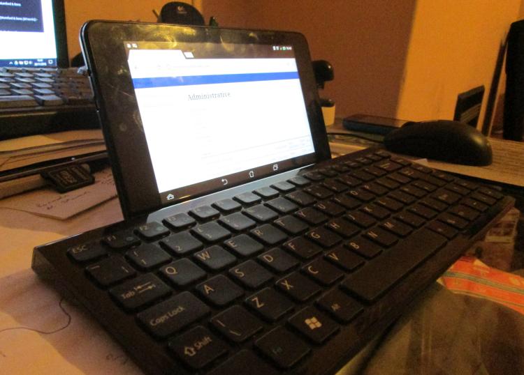 Ren's tablet next to a small bluetooth keyboard on his desk at home