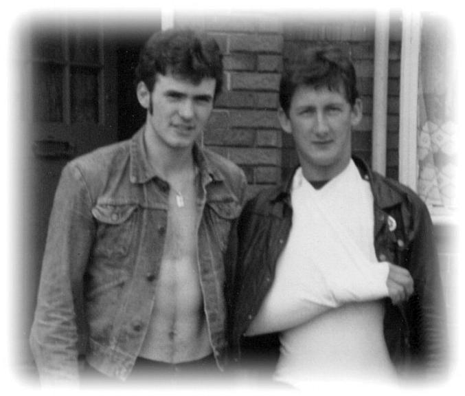 A black and white image of tom with his arm in a sling and friend stood by him