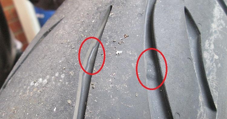 The tread wear indicators in a tyre tread circled in red