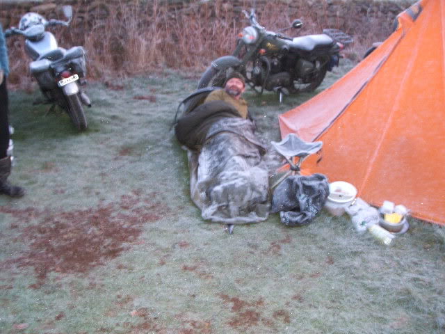 A man sleeping in a bivvy bag on icy ground