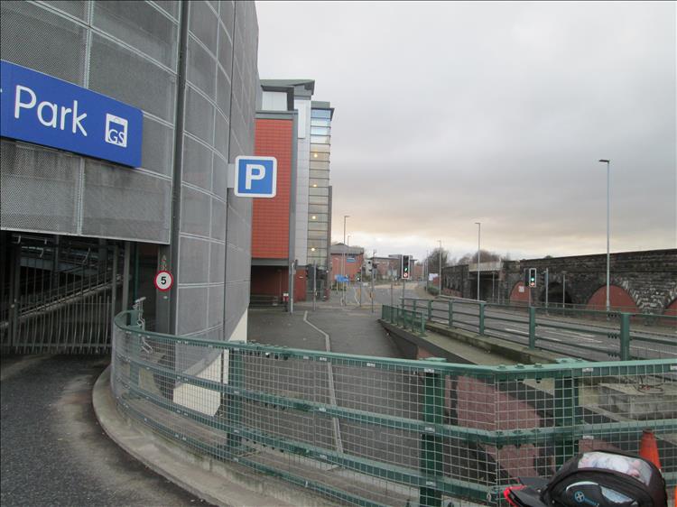 A steel car park and tarmac and traffic lights, no countryside