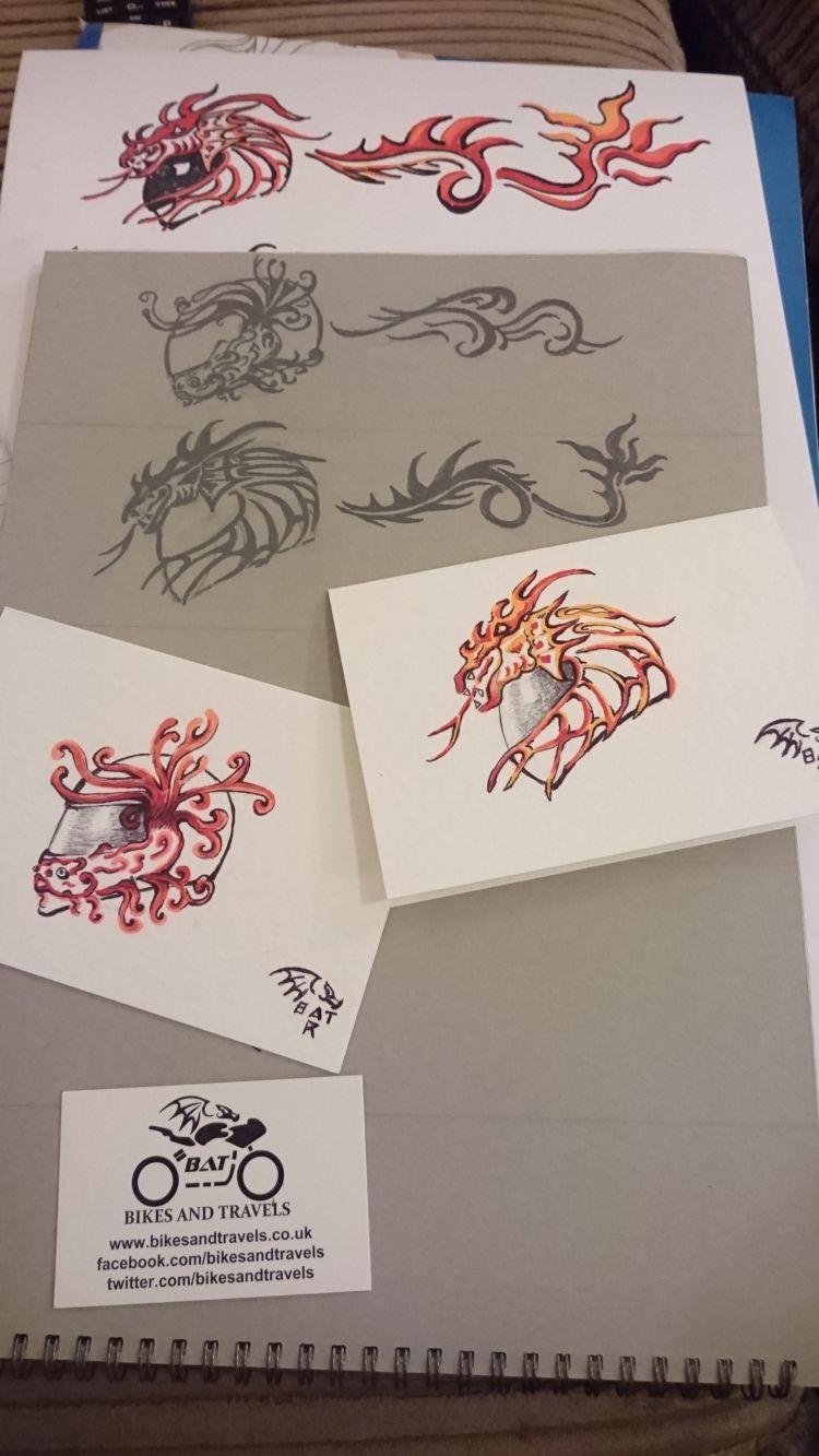Various papers with dragon and fire motifs drawn on helmet outlines