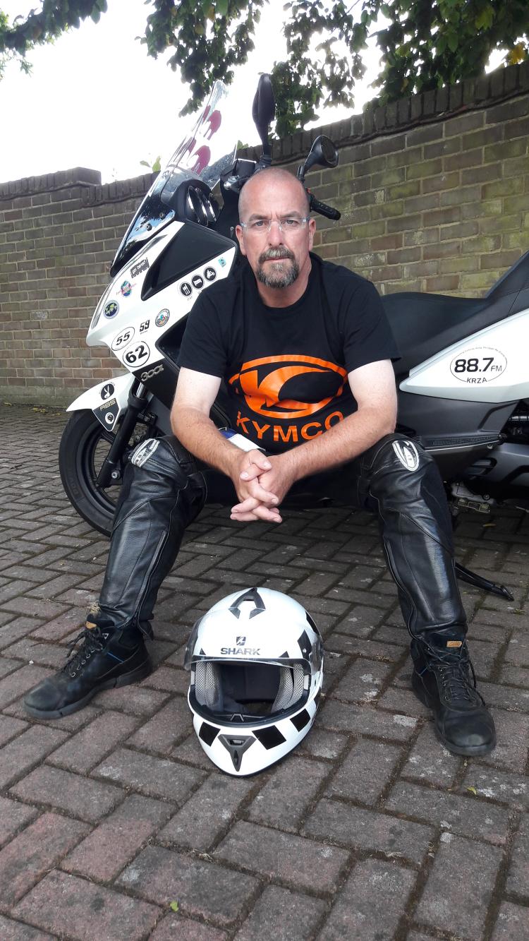 Stephen sits infront of his much travelled Kymco 300