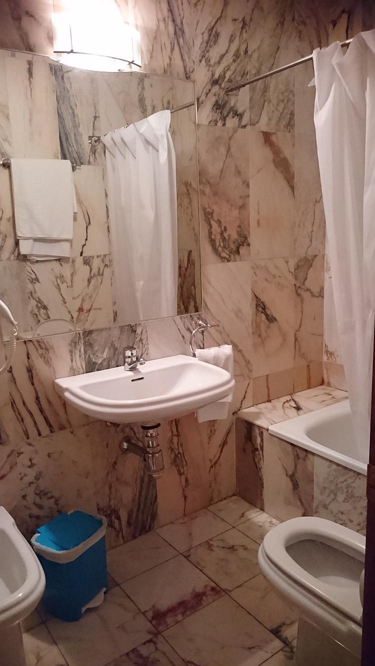 The bathroom of the hotel has smart marble effect tiles and a big mirror