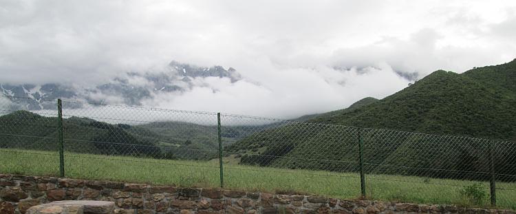 Coulds and mist shroud the rocky snow capped ridges of the Picos
