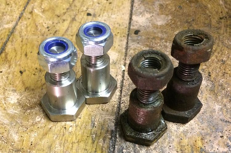 2 shiny new pivot bolts and nuts next to 2 very old, rusty and bent pivot bolts
