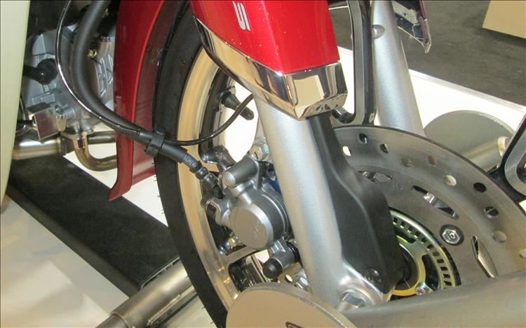 The front brake disc, ABS ring and telescopic forks on the C125 Cub