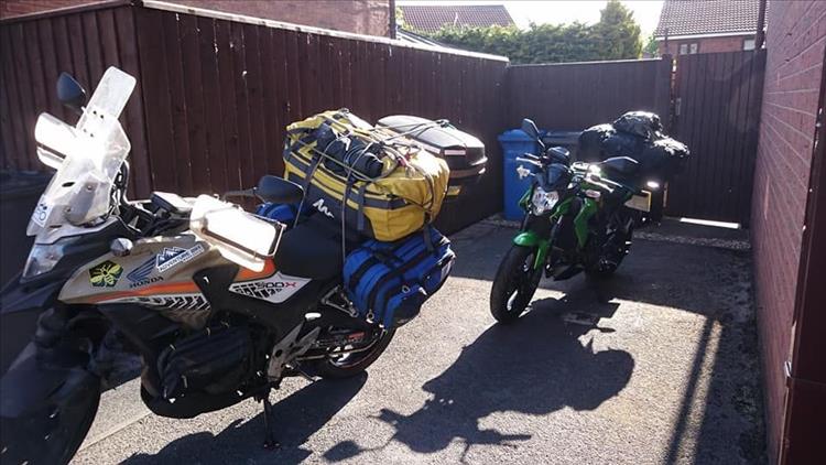 Both motorcycles are heavily laden with luggage as they prepare to leave Sharon's place