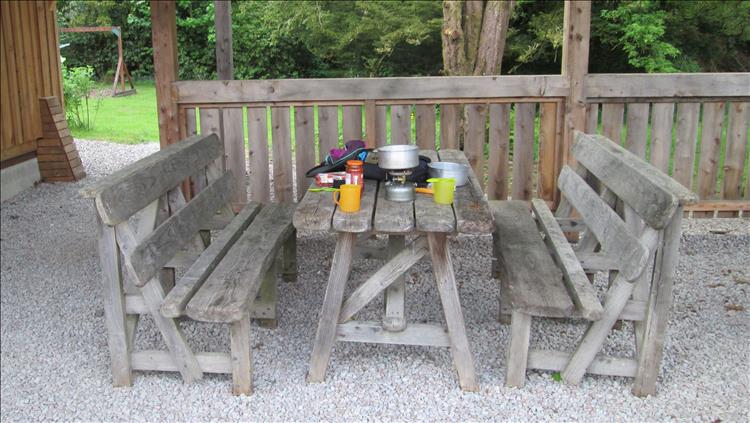 Outdoor table and bench set covered in cooking kit at Glendaruel Campsite