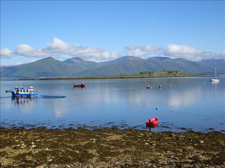 calm waters, a few fishing boats and stunning scenery at Port Appin Scotland