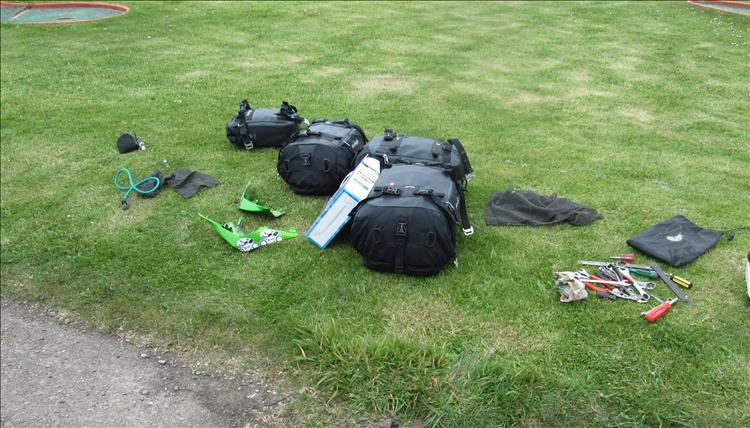 Sharon's bags and Ren's tools spread across the grass at the campsite