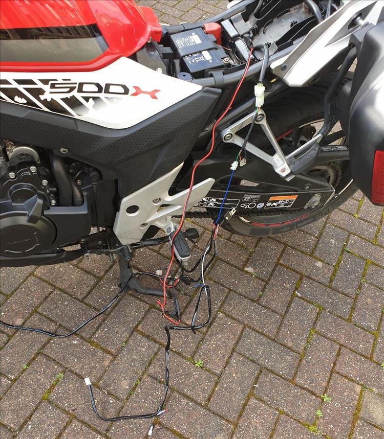 Wires draped from the battery and side panels on the Honda