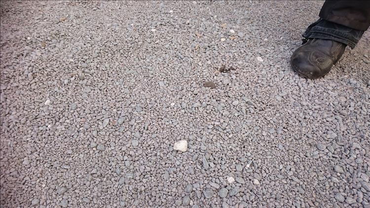 Close up of the gravel shows larger than average and rounded stones, with a boot for scale