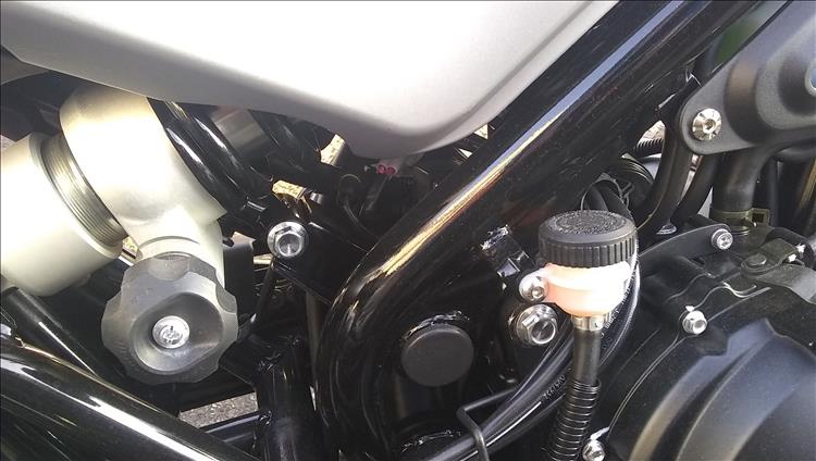 The rear shock has a large knob to adjust the preload and the rear master cylinder is easily accessible