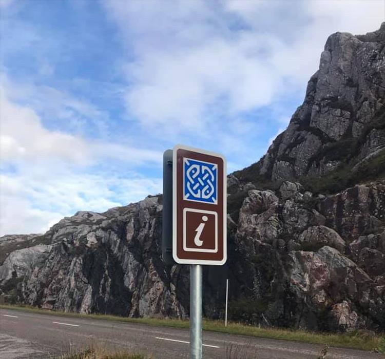 A brown sign with a blue symbol indicating this is a rock route