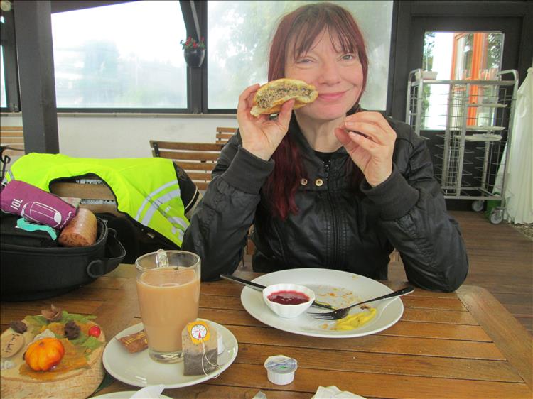 Sharon smiles holding the Germanic burger that is half eaten