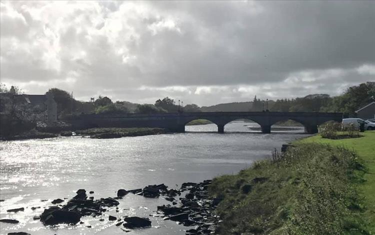 A stone bridge with arches spans a river in the small town of Thurso