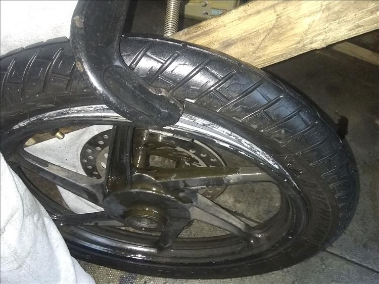 Breaking the bead on the motorcycle tyre using a g-clamp and some wood