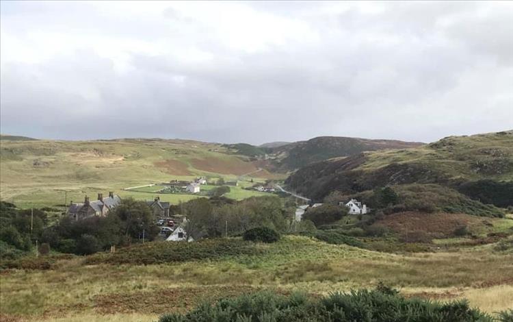 ROLLING HILLS AND MOORLAND with a handful of white painted houses of Bettyhill