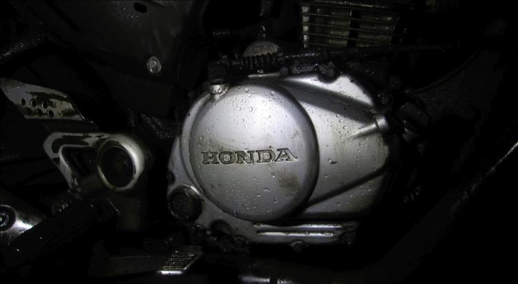In the dark we can make out the crankcase of the engine that is wet on Ren's 125