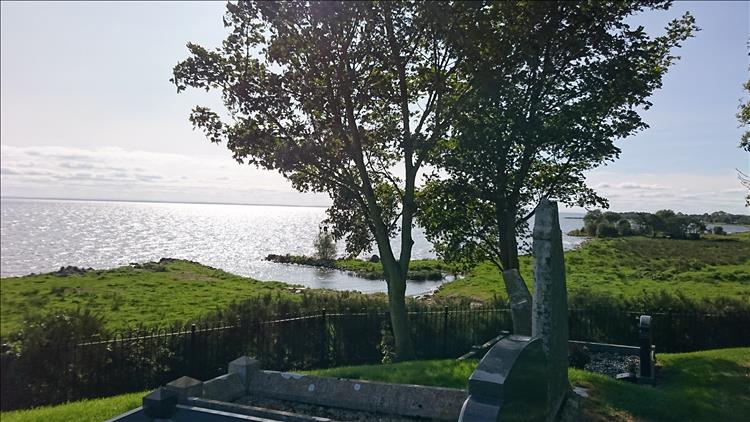 A grave faces out over the calm scenery of the large Lough Neagh