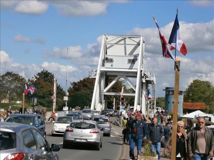 The steel framed Pegasus Bridge with lots of road traffic and pedestrians