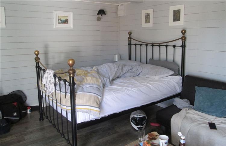 Inside the chalet we see a large double bed and the home comforts