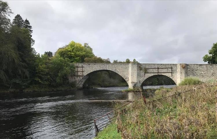 The old stone bridge, solid, chunky with 2 spans across the river