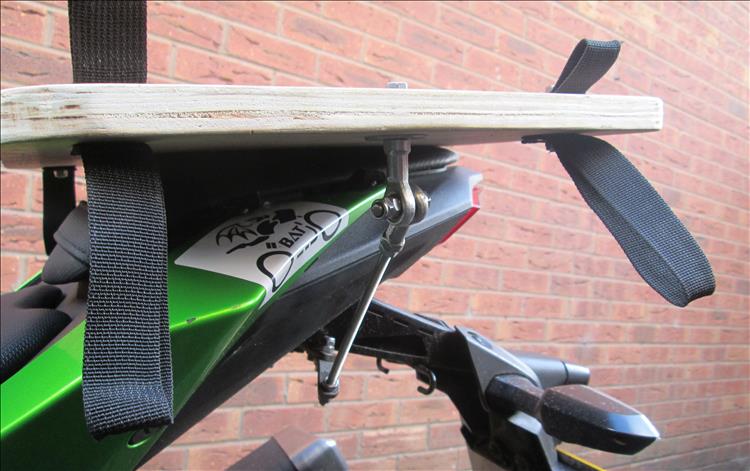 A plank of thick plywood secured to the seat with 2 threaded bars going under the number plate mount