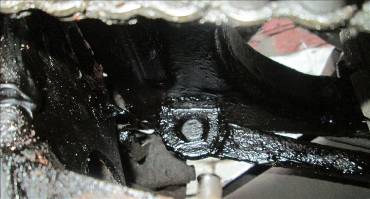 The underside of the swingarm is covered in thick black tar like goo