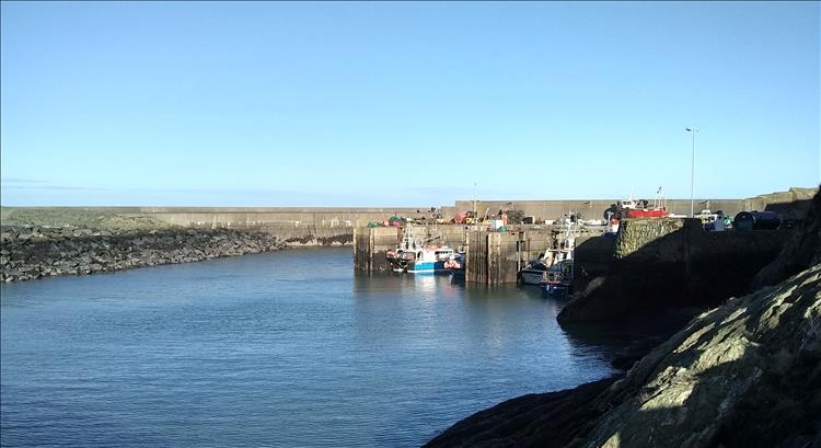 Massive concrete harbour and dock at Amlwch with a few trawlers