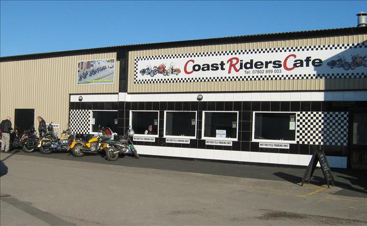 Coast riders fcafe blackpool. A large buiding with a sign and windows