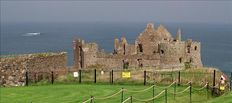 The ruins of a castle set against the sea and grey skies at Dunluce