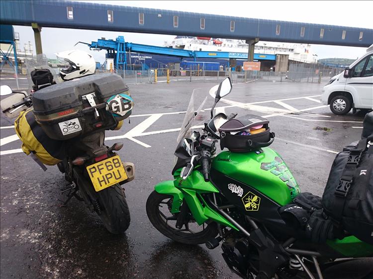The two bikes with the large tarmac area and the ferry in the background at Larne