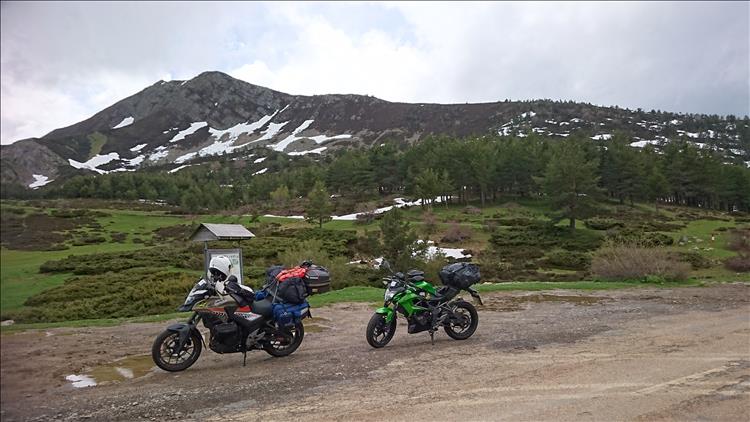 2 motorcycles covered in camping gear on a mountain in Spain