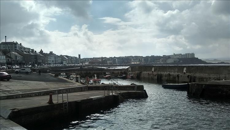 A sturdy harbour and terraced shops around the small bay at Portrush