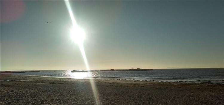 Bright low sun over the sandy beach at Rhosneigr