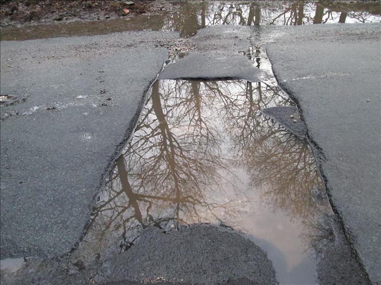 A water filled pothole in the road and we don't know how deep it is