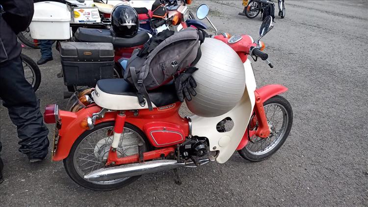 A big round Yoga ball wedged between the seat and handlebars of a C90