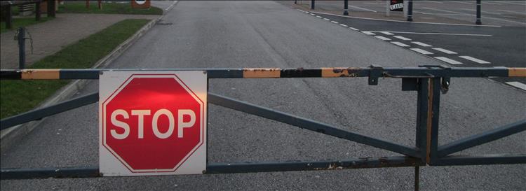 A stop sign on a closed barrier